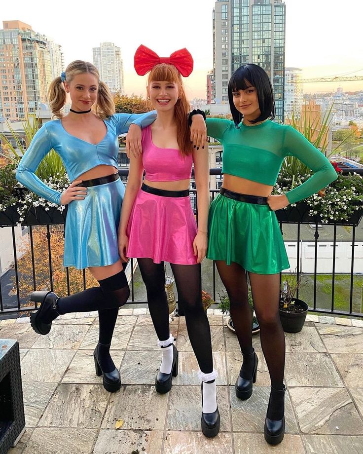 three young women dressed in costumes posing for the camera