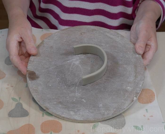 a person is making something out of clay with their hands on the top of it