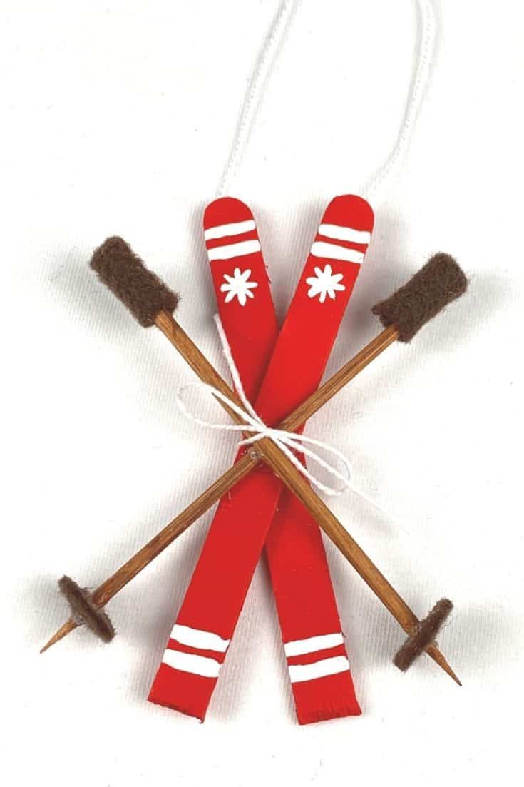 three red and white snowflakes with wooden sticks sticking out of the top