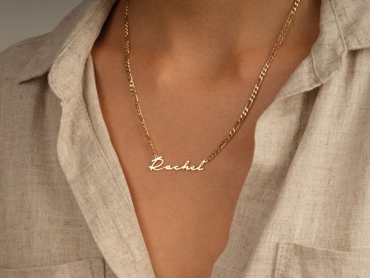 This 14k solid gold name necklace is made from a dainty, yet chic flat figaro chain. Its beautiful finish shines against your skin to accentuate your beauty. Don't forget to choose the best length that works for you! FEATURES • Material: 14k Solid Gold (Stamped 14K for authenticity) • Color Options: Yellow Gold • Chain Style: Flat Figaro Chain • Chain Width: 3.00 mm • Clasp Type: Lobster Clasp • Available Lengths: 14", 15", 16", 17", 18", 19", 20" For custom lengths feel free to contact us. We c Elegant Personalized Curb Chain Necklace, Elegant Necklace With Curb Chain For Personalized Gift, Elegant Curb Chain Necklace For Personalized Gift, Elegant Personalized Yellow Gold Chain Necklace, Elegant Gold Chain Necklace With Custom Name, Figaro Chain Nameplate Jewelry For Anniversary, Dainty Nameplate Necklace With Delicate Chain, Elegant Personalized Curb Chain Jewelry, Elegant Curb Chain Jewelry For Personalized Gift