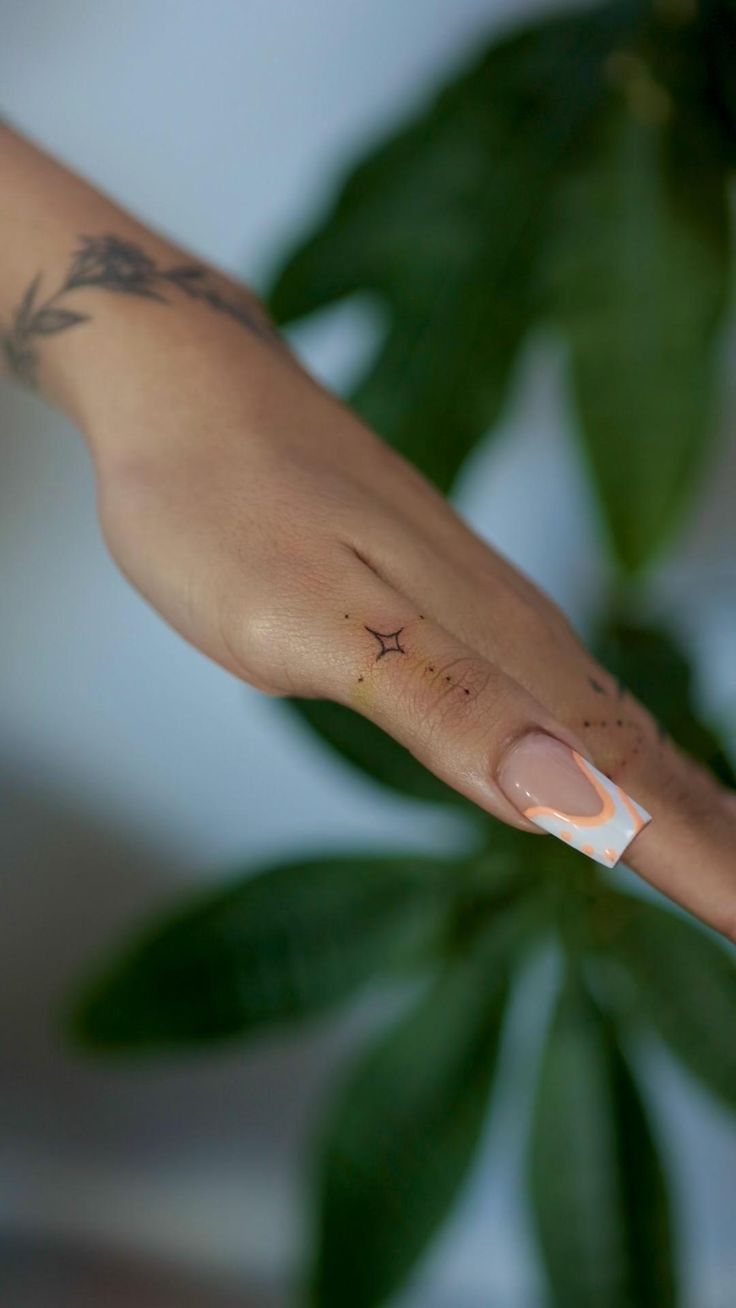 a person's hand with a small tattoo on it