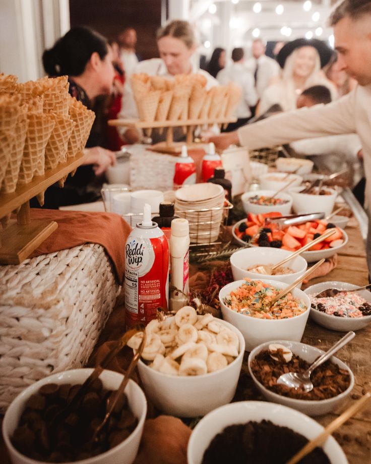 many people are eating food at a buffet table