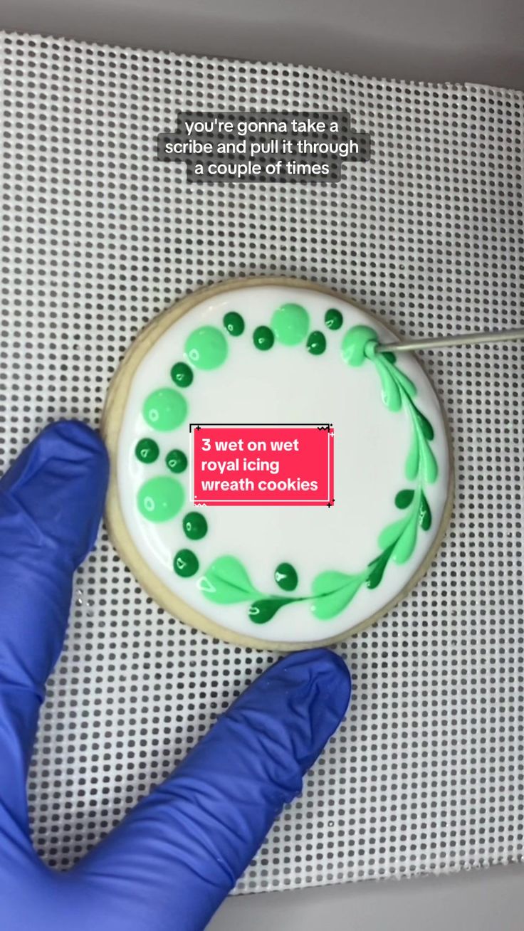 a person in blue gloves is holding a cookie with green icing on it and the words, you're going to make