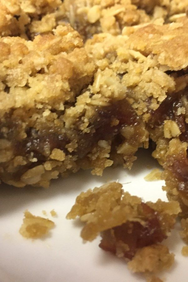 a close up of a piece of food on a plate with crumbled toppings