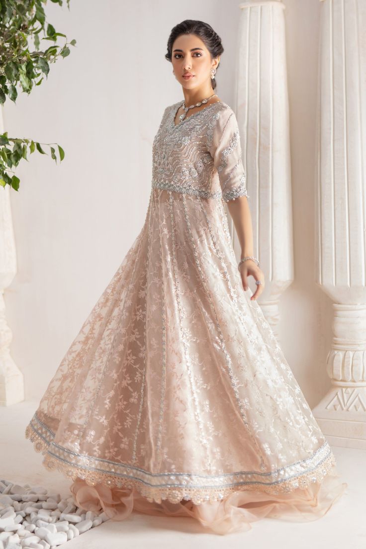 Step up your festive dressing game with our beautifully crafted kalidar over a canvas of stunning embroidered organza, heavily embellished with sequins, beads, crystals, neckline and sleeves beautifully adorned with gorgeous zardozi, mirror work & Resham thread work. Stunning hand-made stylized tassel details at back. This stunning multi panel kalidar is offset with jamawar Lehanga with gorgeous ruffle details & net dupatta featuring sequins & mirror motifs and chan, trimmed with mirror embroidered borders , a Must- have wardrobe staple to carry all Wedding Festivities in effortless style. Shirt Fabric: Pure embroidered Organza & Silk Net Lehanga Fabric: Jamawar Dupatta Fabric: French Net Color: Shell Pink This outfit is only available in Custom size, once order is placed design team will Hand Embellished Saree Dress For Eid, Semi-stitched Hand Embellished Chinon Dresses, Hand Embellished Anarkali Dress For Eid, Designer Unstitched Hand Embellished Salwar Kameez, Anarkali Hand Embellished Semi-stitched Dress, Unstitched Hand Embellished Chinon Salwar Kameez, Designer Hand-embellished Unstitched Salwar Kameez, Unstitched Embellished Chinon Dress, Hand Embellished Semi-stitched Salwar Kameez For Eid