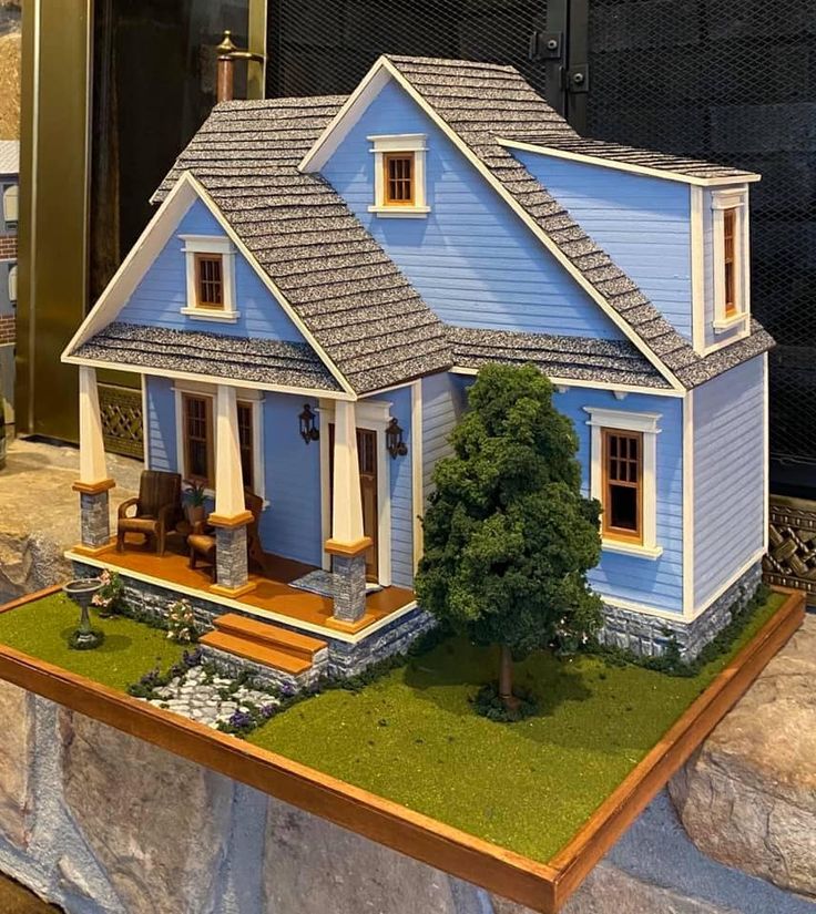 a blue doll house sitting on top of a wooden table