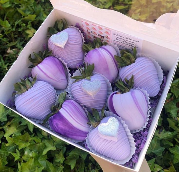 a box filled with purple chocolate covered strawberries