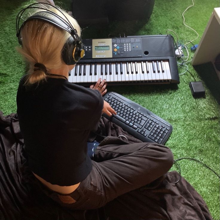 a person sitting in front of a keyboard with headphones on