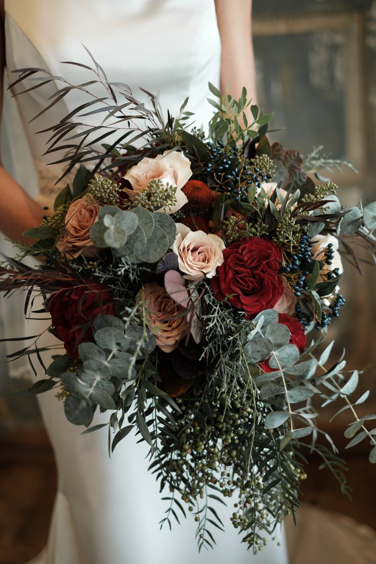 a bridal holding a bouquet of flowers and greenery