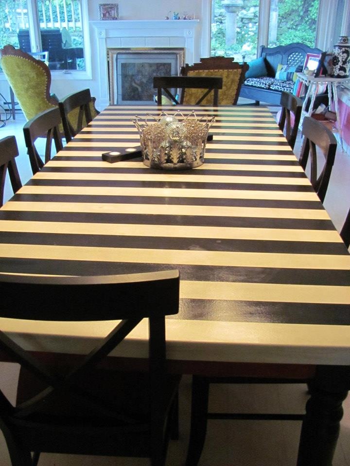 a dining room table with black and white striped chairs