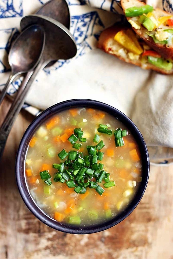 a bowl filled with soup next to a sandwich