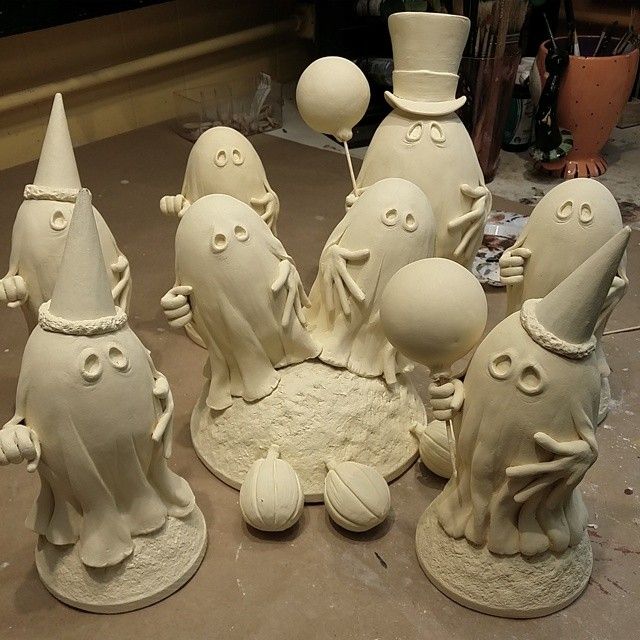 a group of white ceramic figurines sitting on top of a table next to each other