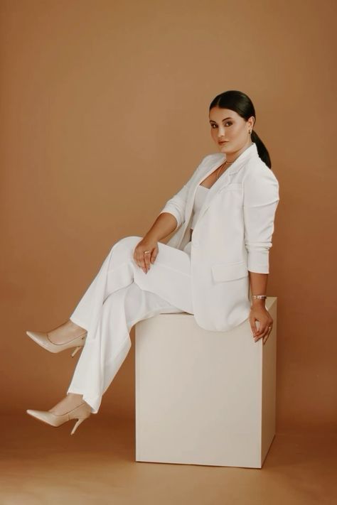 a woman sitting on top of a white box