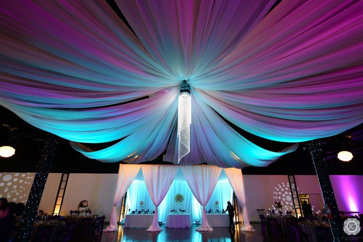 the ceiling is decorated with white and blue draping for a wedding reception or special event