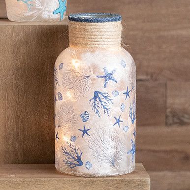 two glass bottles with blue and white designs are sitting on top of a wooden shelf