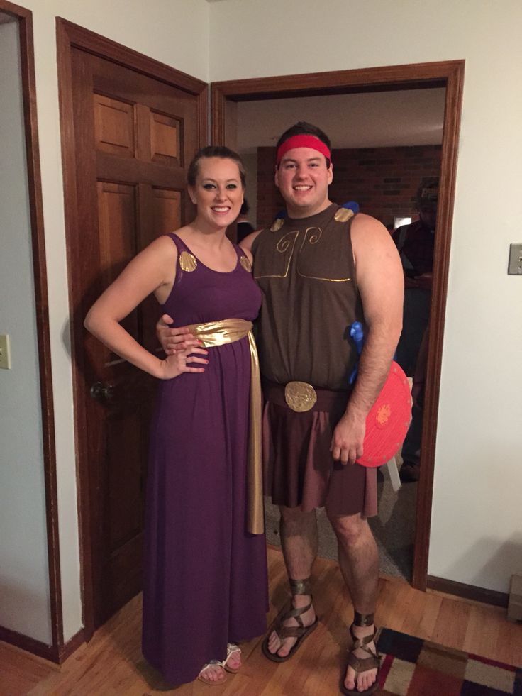 a man and woman dressed up in roman costumes standing next to each other on a hard wood floor