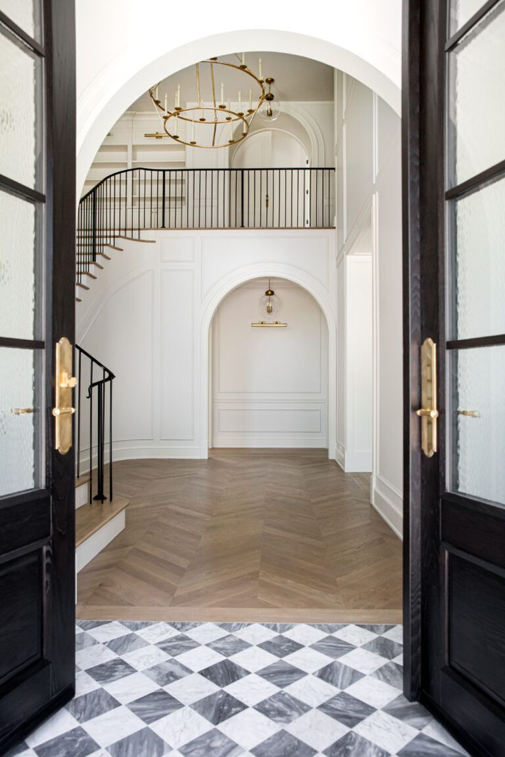 an open door leading to a foyer with black and white checkered flooring on the ground