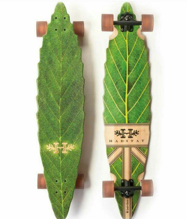 two skateboards with green leaf designs on the front and back, sitting side by side