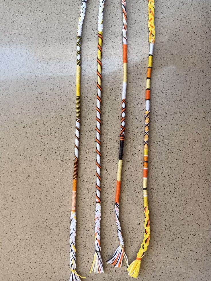 three different colored cords with tassels hanging from them on a counter top,