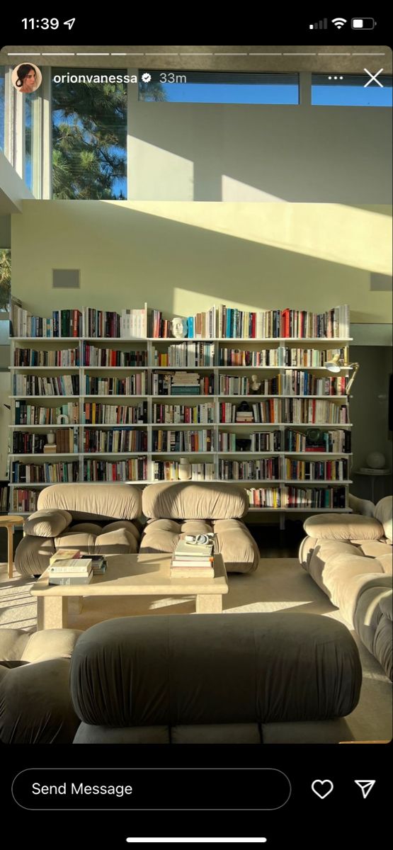 a living room filled with lots of furniture next to a book shelf full of books