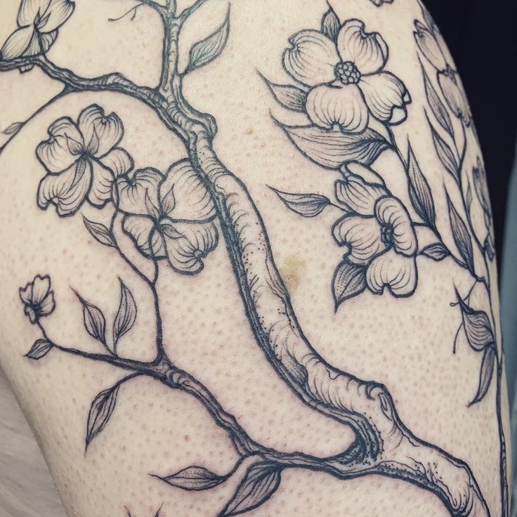 a tattoo with flowers and leaves on it