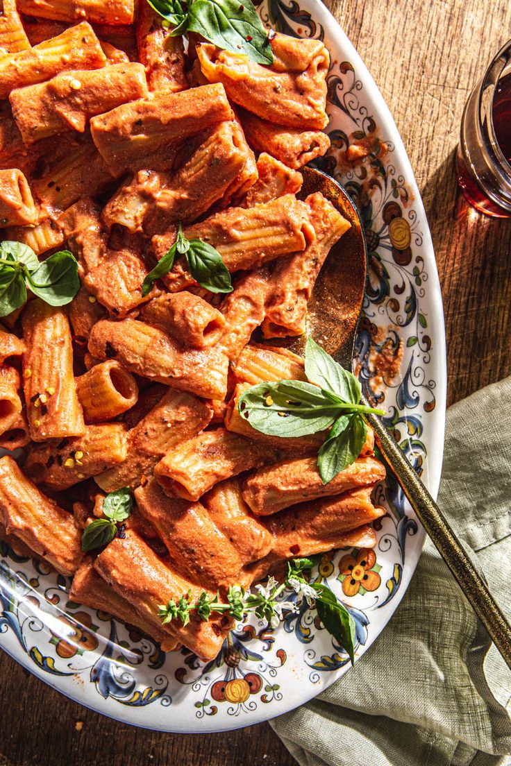 a plate filled with pasta and sauce on top of a wooden table