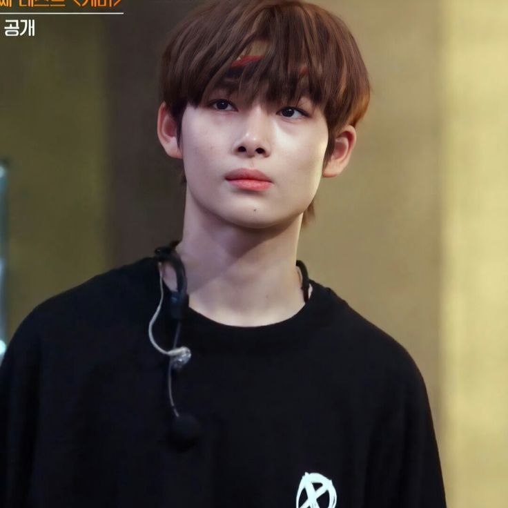 a young man with brown hair wearing a black shirt