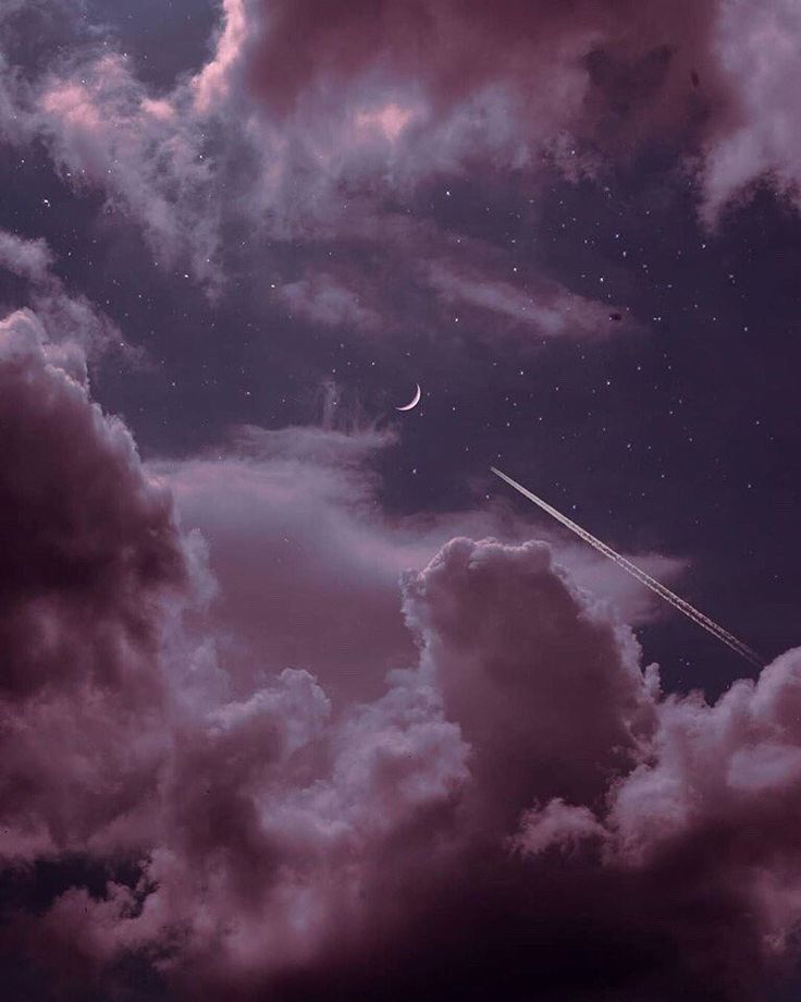 an airplane is flying through the sky with clouds and stars in the background at night