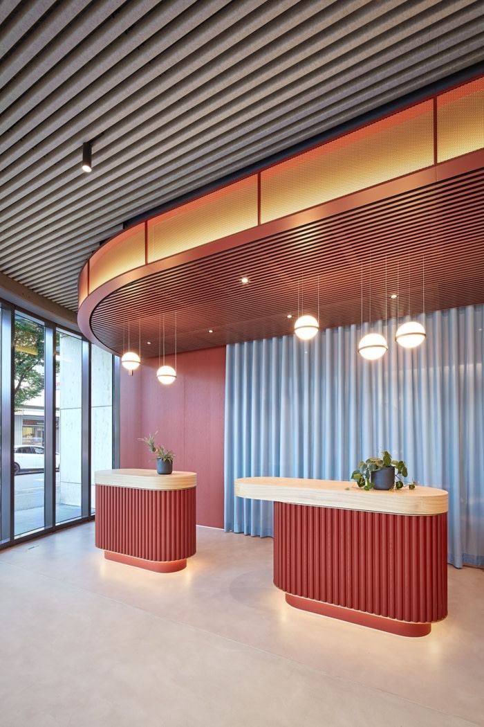 an empty room with two desks in front of large windows and blue curtained walls