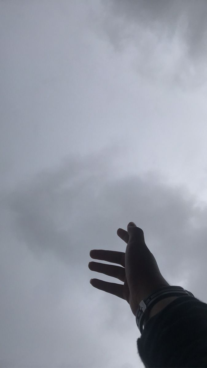 a person is reaching up into the sky