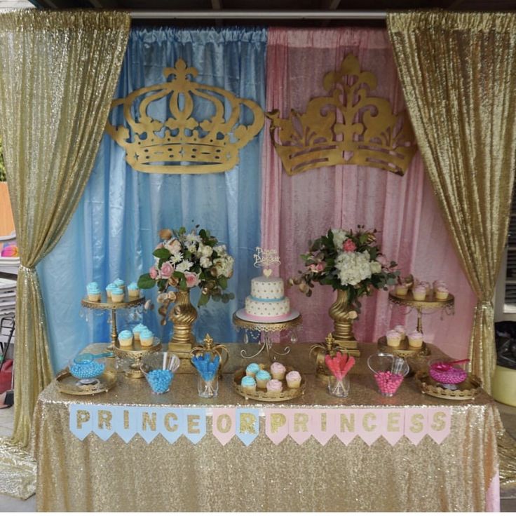 a table topped with cakes and cupcakes under a gold canopy covered in curtains