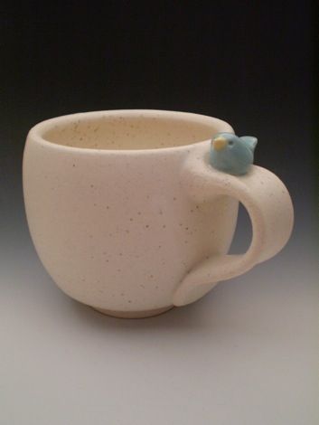 a white cup with a blue bird on it