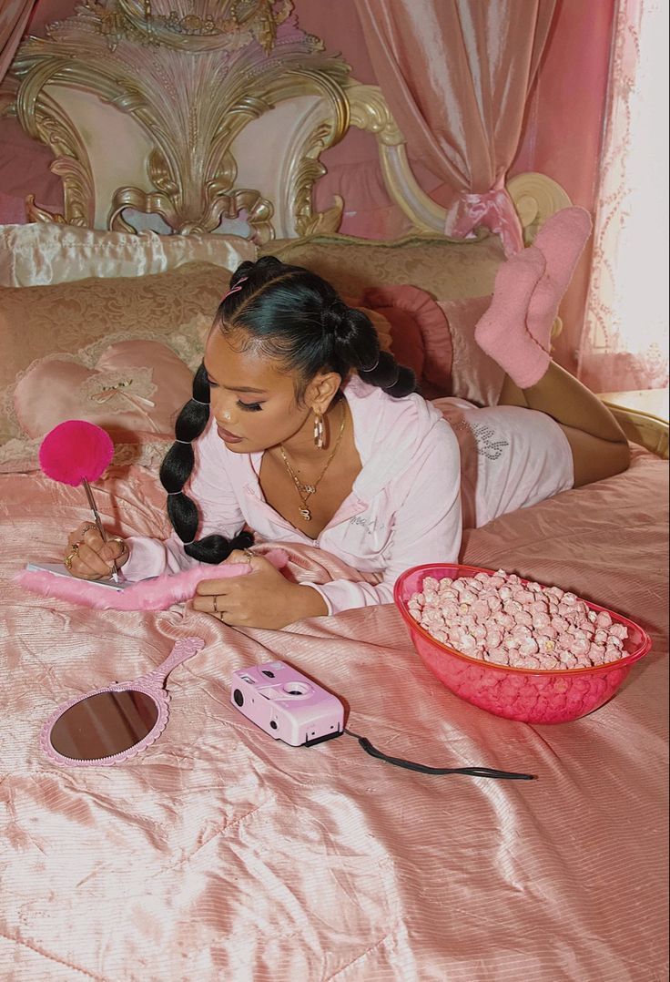 a woman laying on top of a pink bed