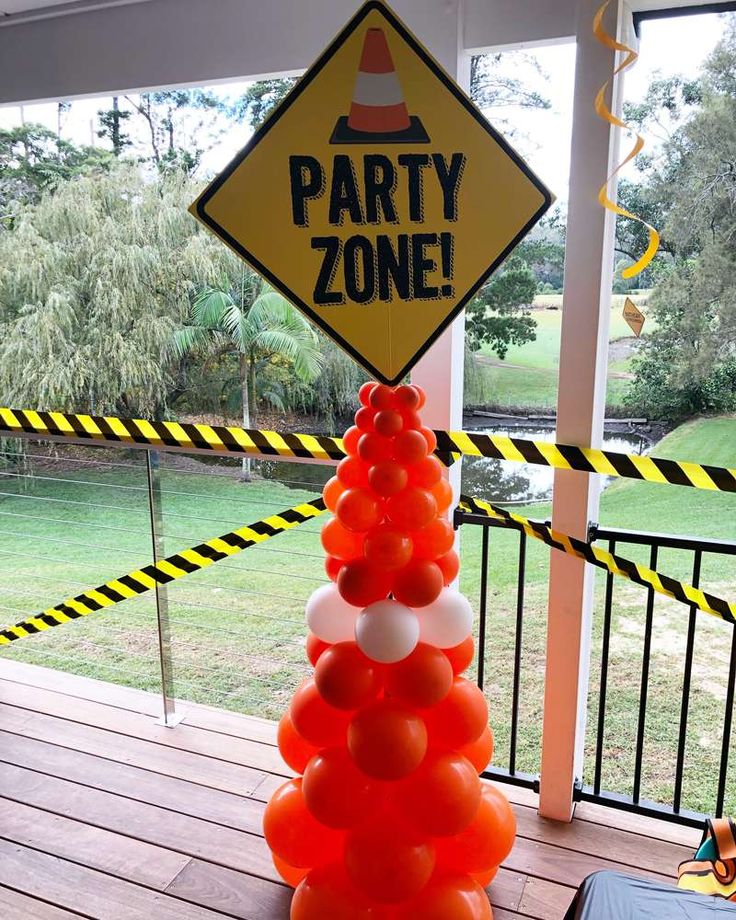 an orange and white party cone is on the porch near a sign that says party zone