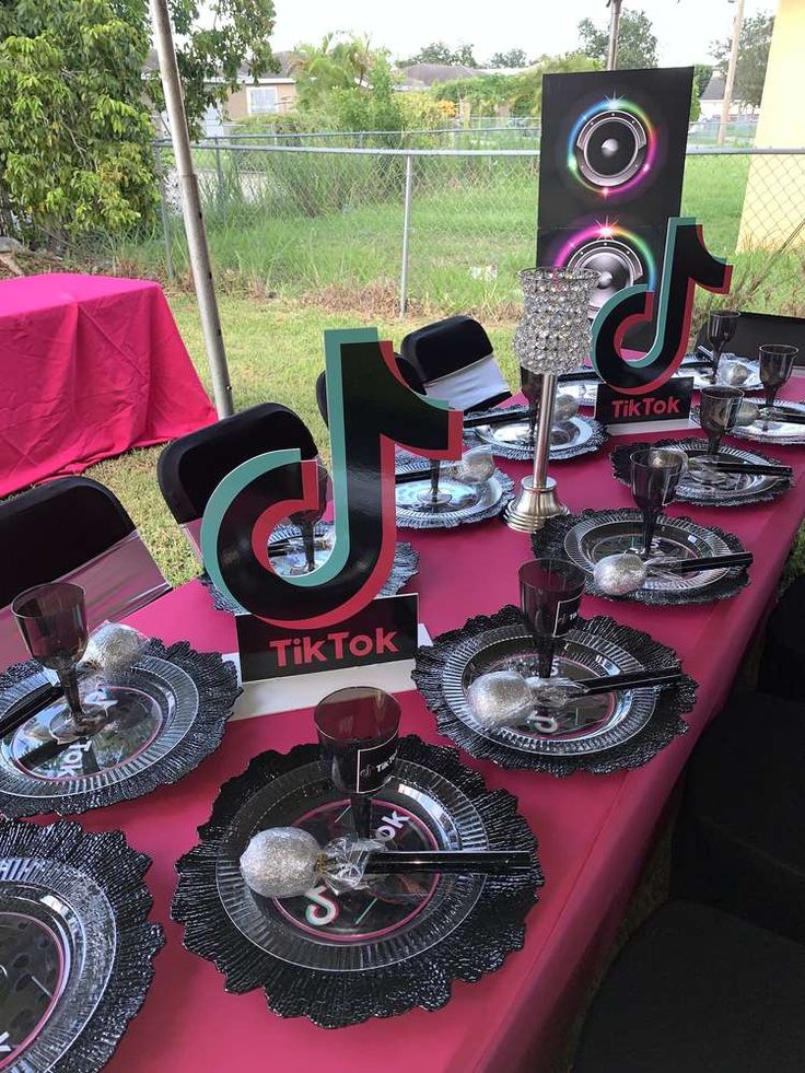 the table is set up with black and silver plates, napkins and place settings