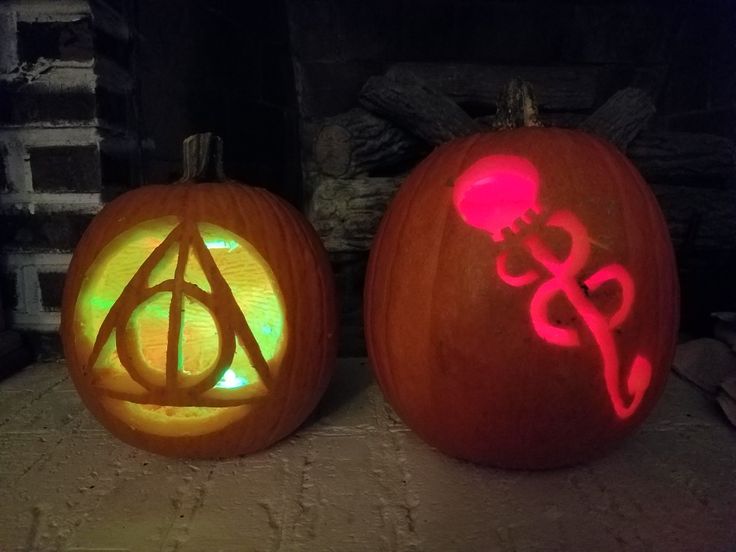 two carved pumpkins with harry potter symbols on them