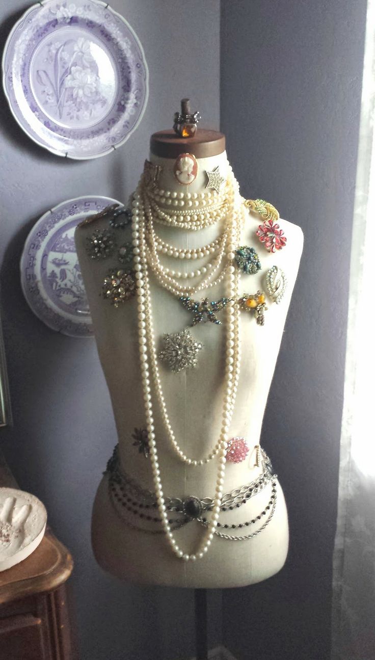 a mannequin is adorned with pearls and other jewelry