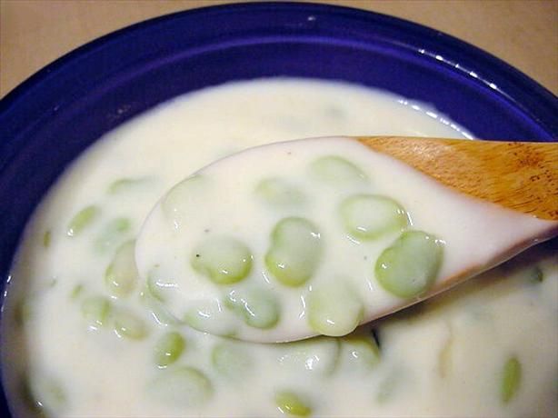 a blue bowl filled with soup and a wooden spoon