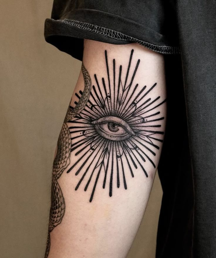 a person with a tattoo on their arm and an all seeing eye in the middle