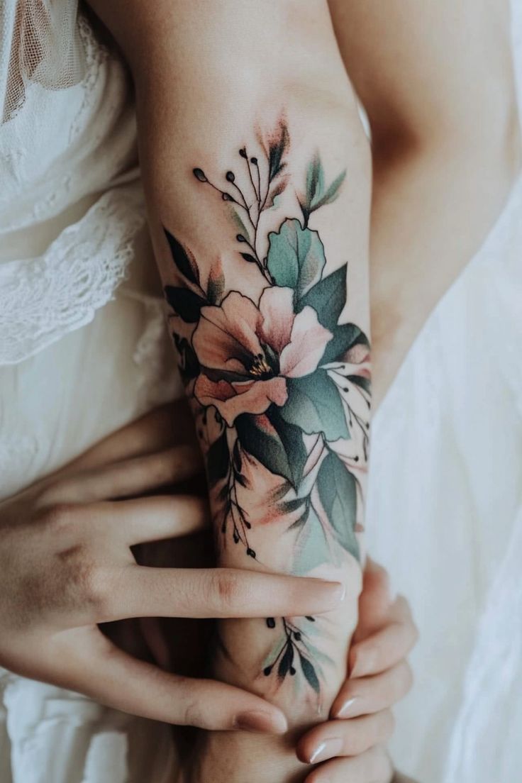 Floral tattoo on a person's forearm with hands gently touching it. Cover Up Flowers Tattoo, Muted Floral Tattoo, Flower Tattoo Cover Up, Beauty For Ashes Tattoo, Floral Tattoo Coverup, Mountain Tattoos For Women, Floral Cover Up Tattoo, Calla Lily Tattoo, Floral Tattoo Ideas