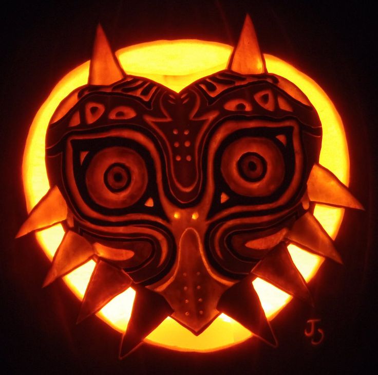 a carved pumpkin with an image of a demon's head in the middle of it