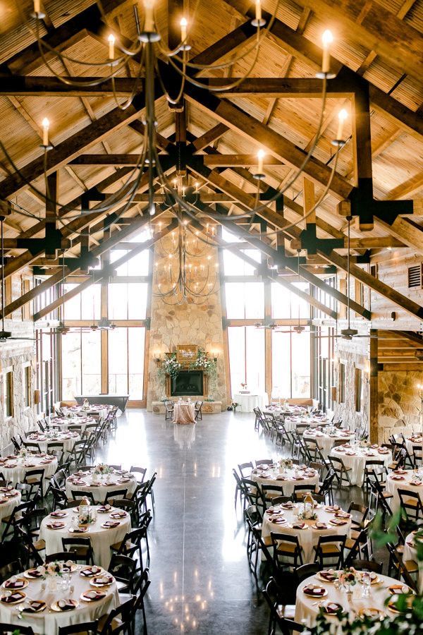 the inside of a large building with tables and chairs set up for an elegant dinner