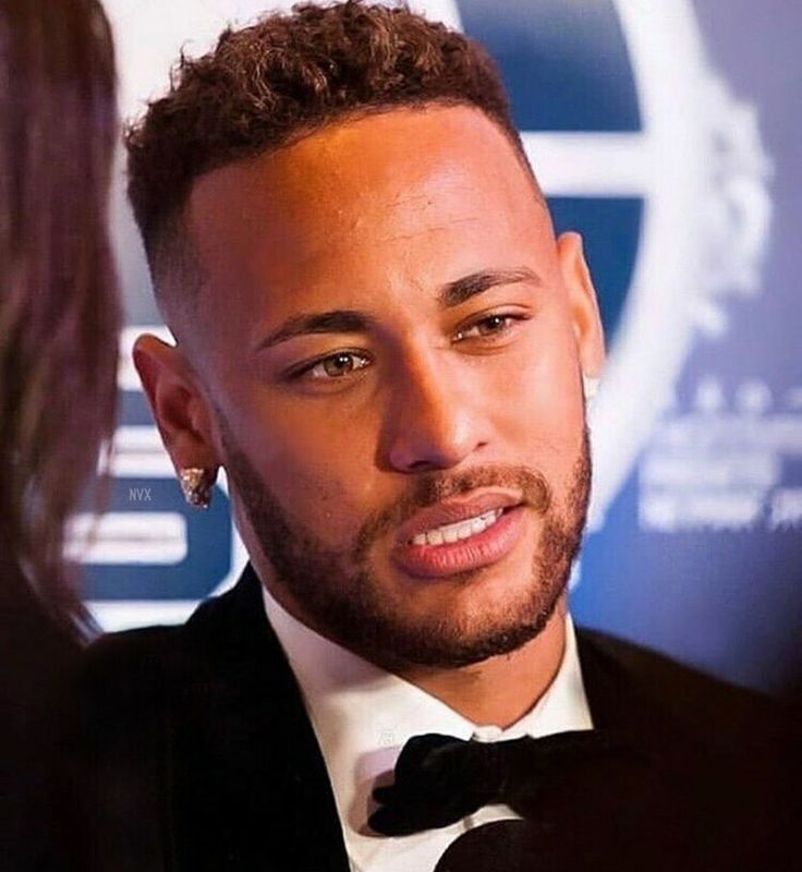 a close up of a person wearing a suit and tie with a microphone in front of him