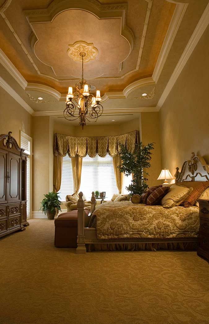 a bedroom with a large bed and chandelier in the middle of it's ceiling