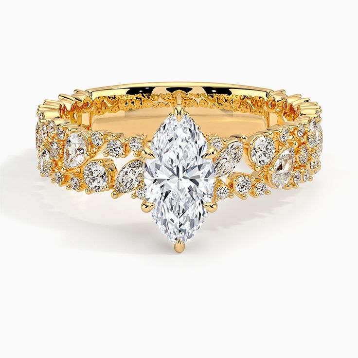 a yellow gold engagement ring set with a pear shaped diamond in the center and side stones