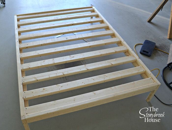 a bed frame being built in a room with tools and supplies on the floor next to it