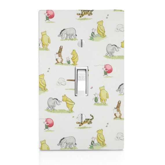 a light switch cover with winnie the pooh and friends pattern on it, sitting in front of a white background