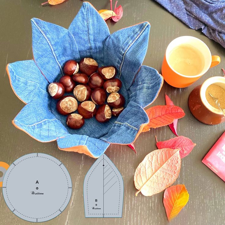 an arrangement of autumn leaves and acorns on a table with paper cut outs