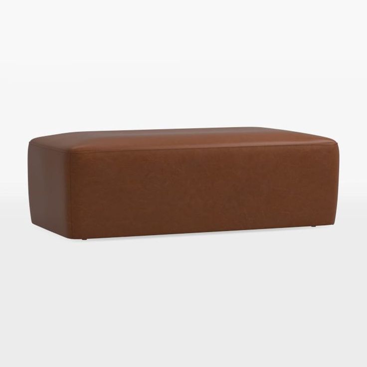 a brown leather ottoman sitting on top of a white floor