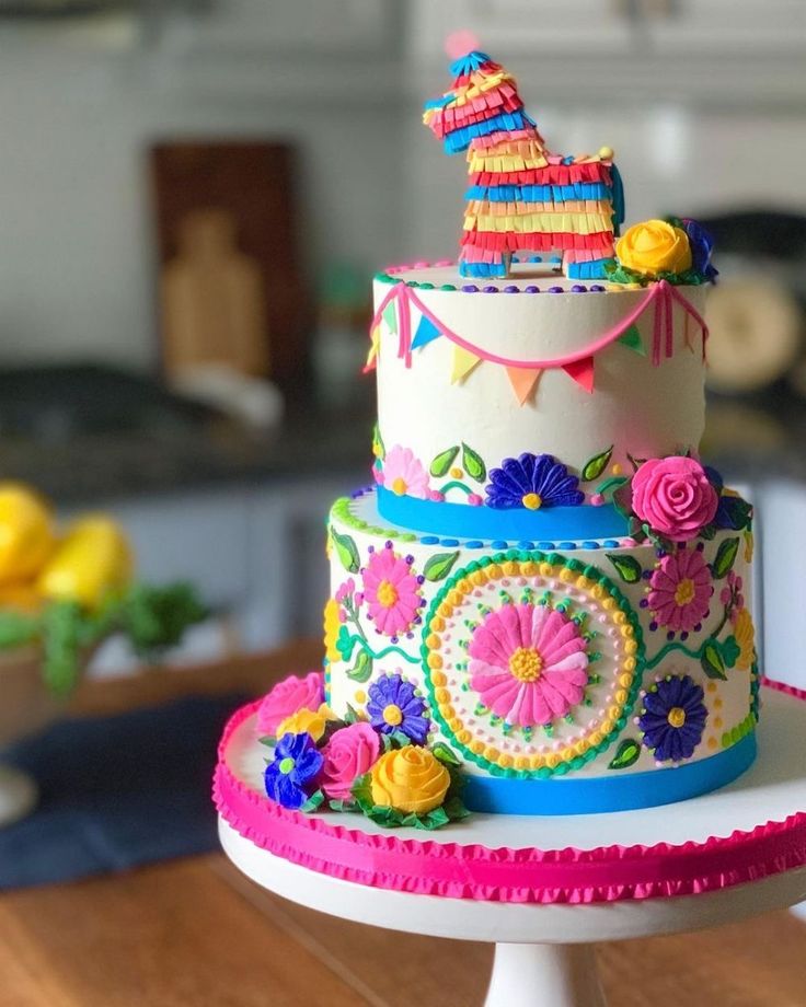 a multi - tiered cake decorated with flowers and decorations